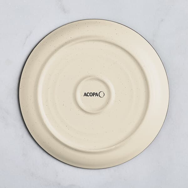 An Acopa cream white stoneware plate with black specks on it.