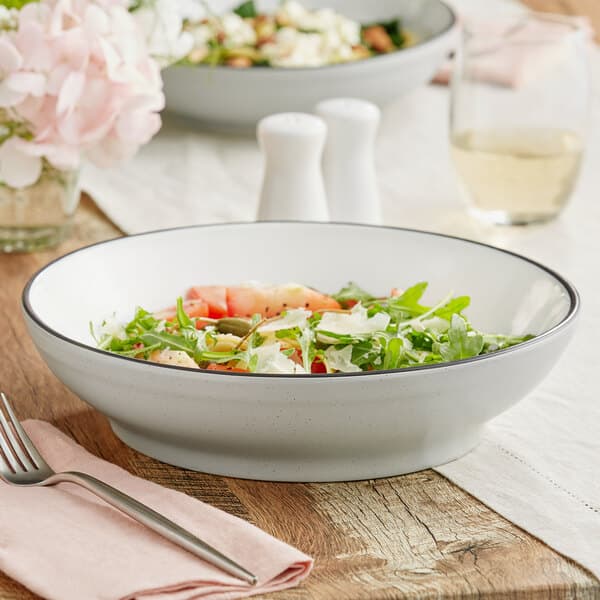 An Acopa Embers stoneware pasta bowl filled with salad on a table with a fork.