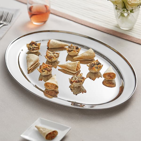 An Acopa stainless steel oval platter with a burrito and tortilla chips on it.