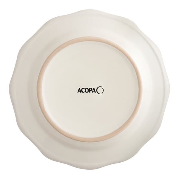 An ivory Acopa stoneware plate with a scalloped edge and brown rim.