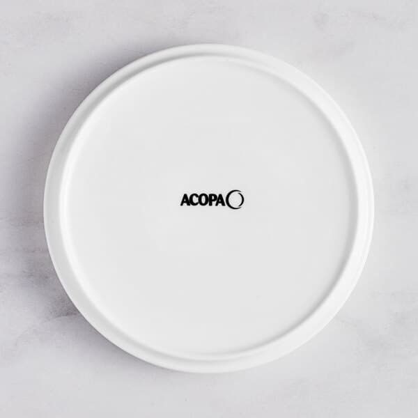 A white Acopa Lore porcelain plate with raised rim and black text.