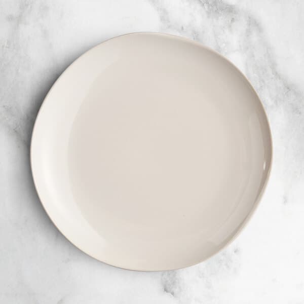 An Acopa Highlands white coupe china plate on a marble surface.