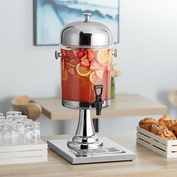 An Acopa stainless steel and polycarbonate beverage dispenser with fruit and a drink.