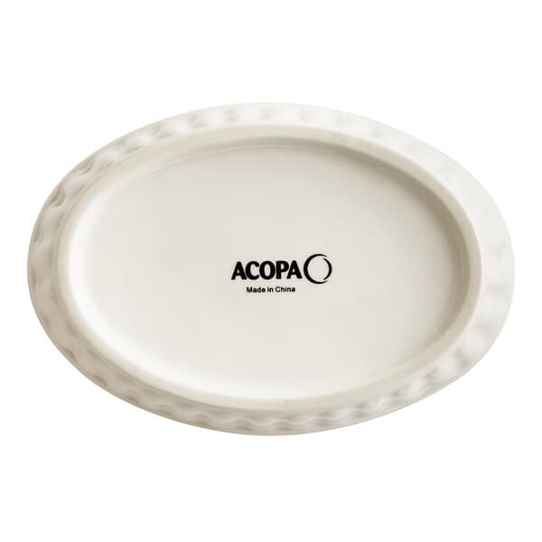 An ivory fluted oval Acopa porcelain dish with black text.