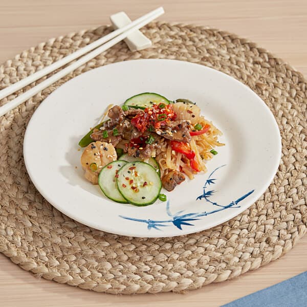 An Acopa Biru melamine plate with food and chopsticks on a place mat.