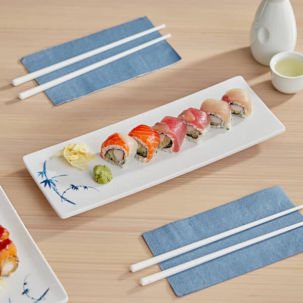 A rectangular white melamine tray with sushi on it.