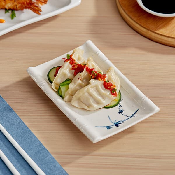 A rectangular Acopa Biru melamine plate with a meal on a table.