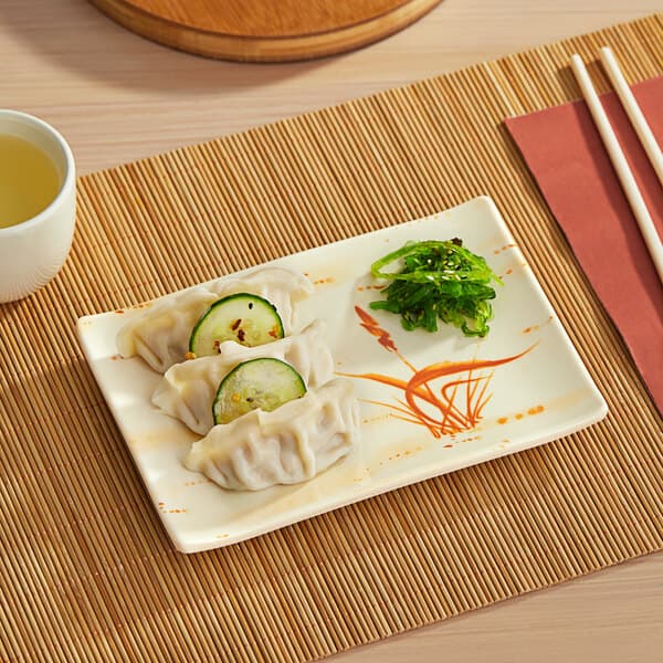 A rectangular Acopa Brassia melamine plate with a plate of food and chopsticks on a table.