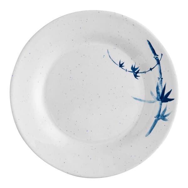 A white plate with blue bamboo painted on it.