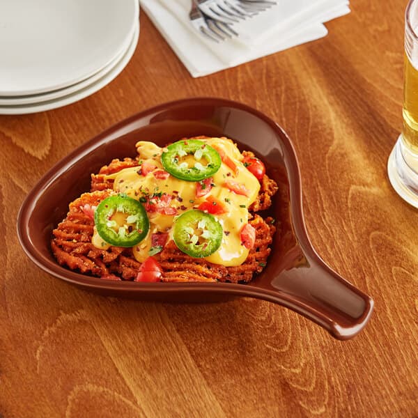 An Acopa brown stoneware fry pan server filled with food on a table.
