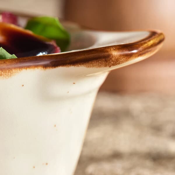 A close up of a bowl of food in an Acopa Keystone porcelain mini rarebit dish with a green leaf on top.