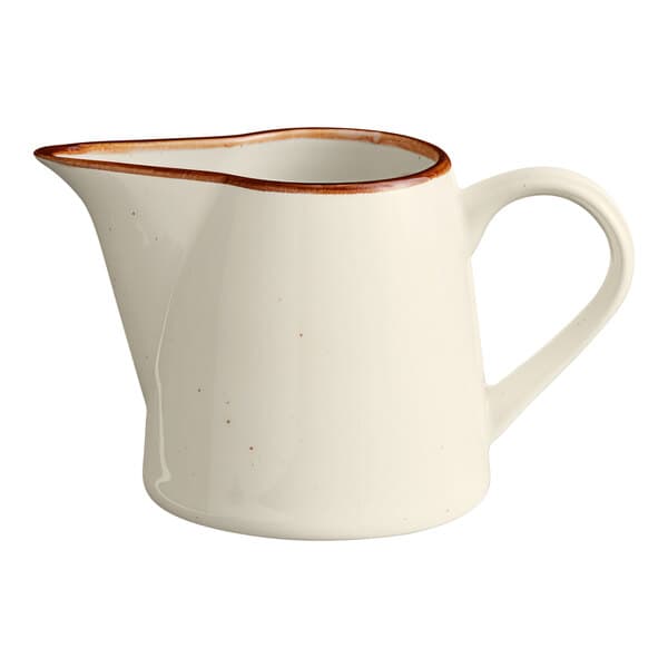 A white porcelain creamer with a brown rim.