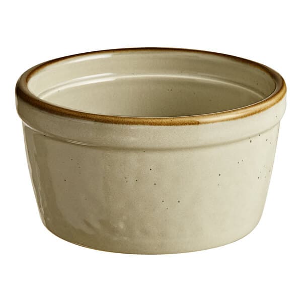 A white porcelain ramekin with brown rim.