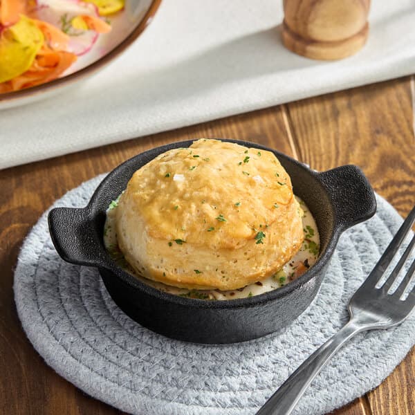 A small white Acopa Keystone porcelain casserole dish with food on a plate.