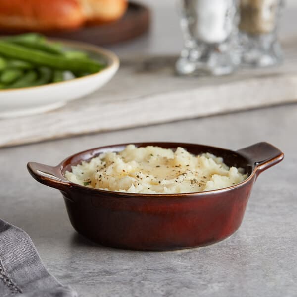 A bowl of mashed potatoes and green beans served in an Acopa Keystone porcelain mini casserole dish.
