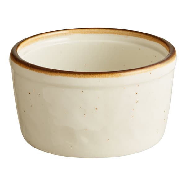 A white porcelain ramekin with brown specks on the rim.