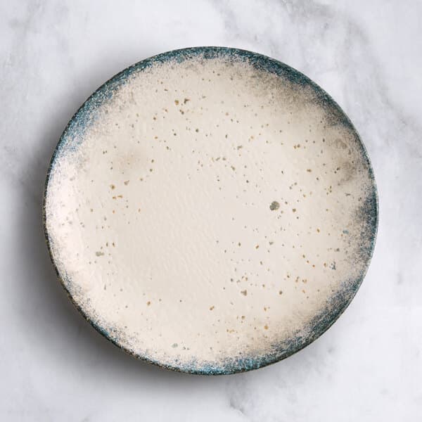 A round gray porcelain coupe plate with a speckled design and a slightly textured surface.