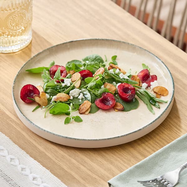 A round gray porcelain plate with a slightly raised rim, shown with a salad on top.