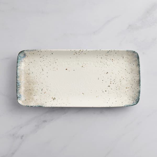 A white rectangular plate with specks.