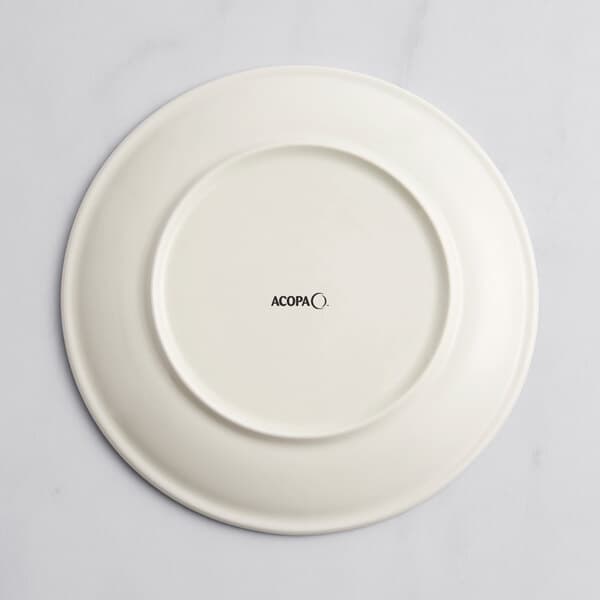 A white Acopa porcelain coupe plate with a circular design in black