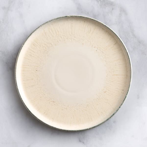 An Acopa Cape white porcelain plate with a thin rim on a marble surface.