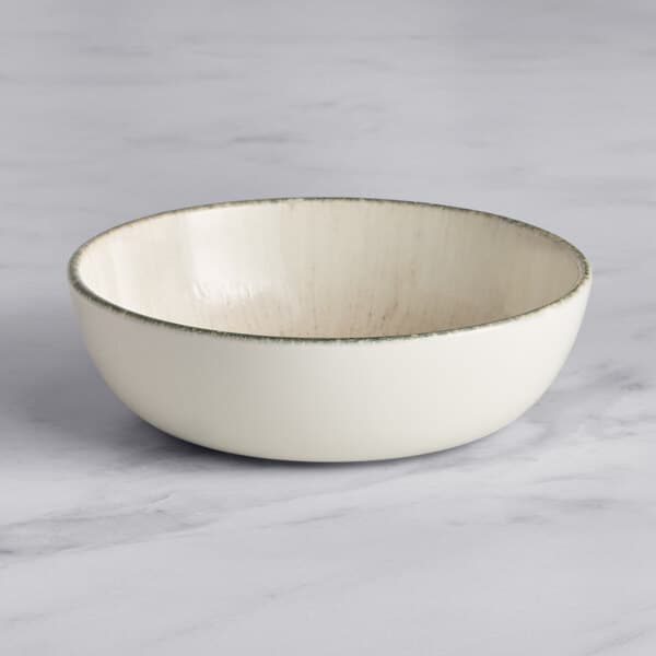 An Acopa Cape white porcelain bowl with a green rim.