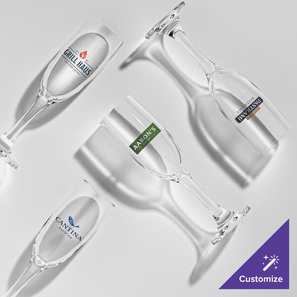 A set of clear 6 oz. flute glasses, each with a different customizable logo printed on the side.