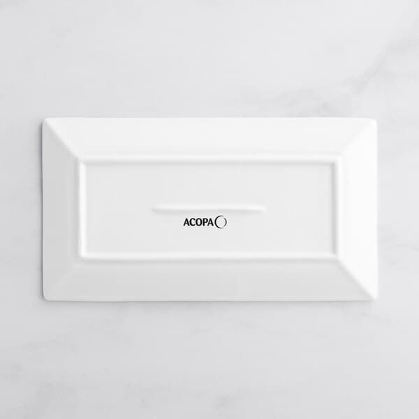 A bright white rectangular porcelain platter with black text that reads "Acopa" on it.